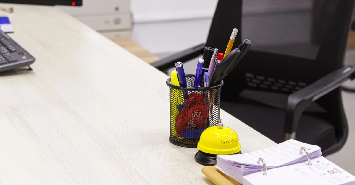 Aufgeräumter Büroschreibtisch mit Stifthalter und Klemmbrett für einen sauberen Arbeitsplatz.