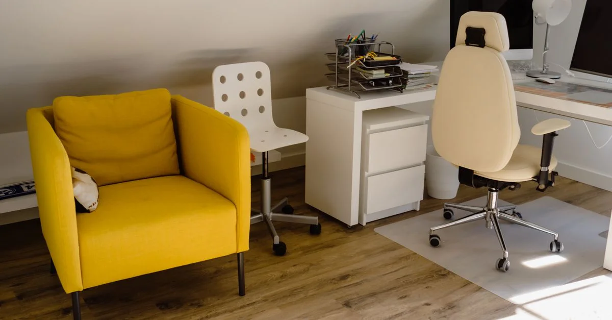 Helles Home Office mit einem gelben Stuhl und organisiertem Schreibtisch-Setup.