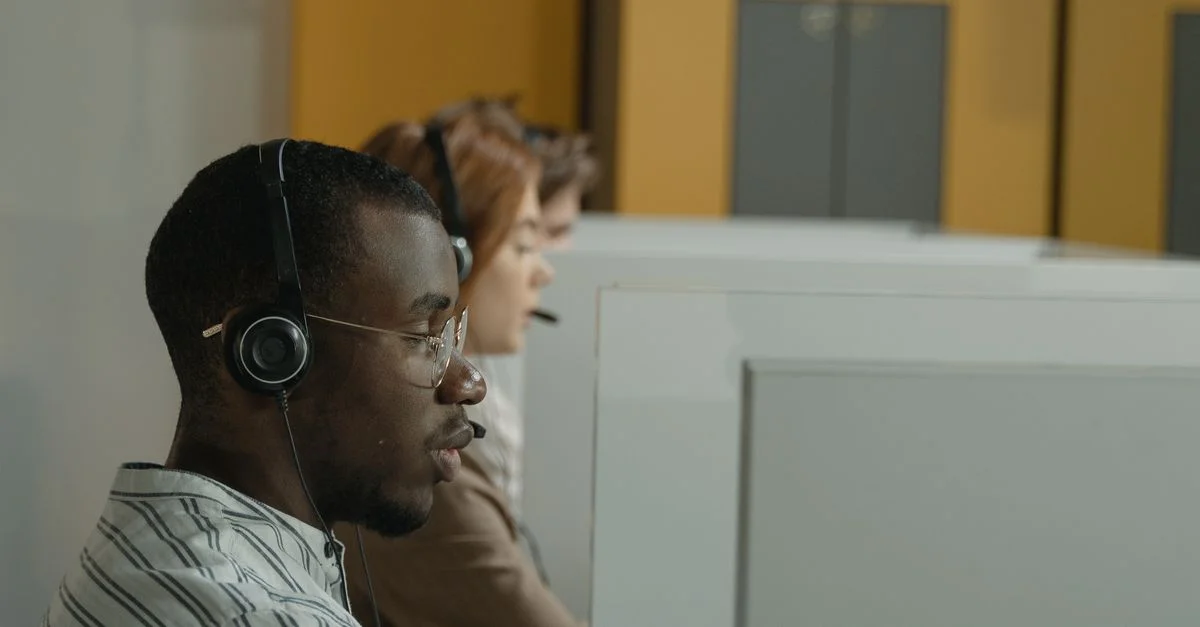 Professionelle Callcenter-Mitarbeiter, die in einer modernen Büroumgebung arbeiten, mit Schwerpunkt auf Teamarbeit und Kundenservice.