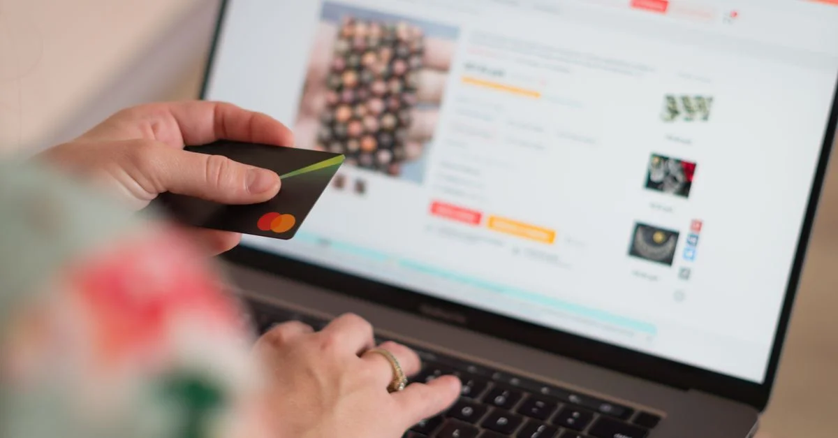 Engagiert in Online-Shopping mit einer Kreditkarte und einem Laptop für Bequemlichkeit und Einfachheit.