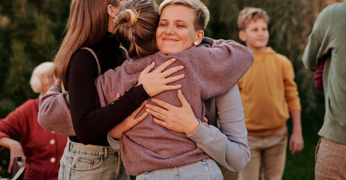 Ein rührender Moment eines Familienbesuchs, bei dem sich Mitglieder glücklich im Freien umarmen.